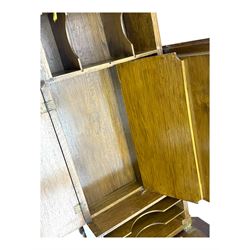 Edwardian oak metamorphic 'Britisher Writing Table', rectangular hinged top revealing correspondence compartments and hinged writing surface with underside storage, flanked by twin hinged compartments with dividers, on turned supports