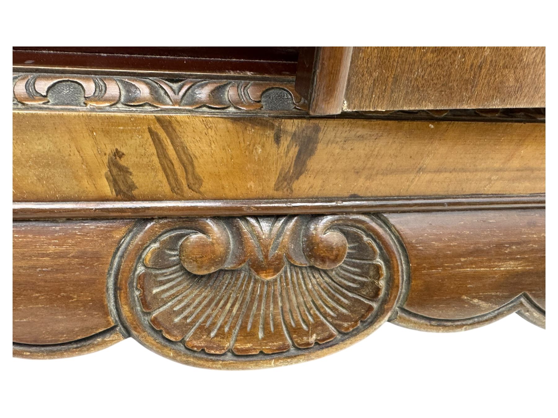 Early 20th century walnut veneered cocktail cabinet, shaped and carved foliate pediment above a pair of arched panelled doors with figured veneers and ornate cast escutcheons, interior is mirrored on the base and back, slide out mirrored shelf, flanked by foliate carved uprights, over a conforming lower cabinet, all raised on shaped apron and scroll carved cabriole feet