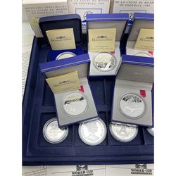 Nine commemorative coins relating to the France 1998 World Cup, some cased with certificates, in a blue coin storage box