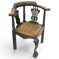 Pair of 19th century carved oak corner chairs, cresting rail carved with central floral bouquet with trailing foliage extending to the scroll arm terminals, pierced back splats with rosette motifs over drop-in rush seats, front cabriole support with acanthus carved knee and ball-and-claw foot