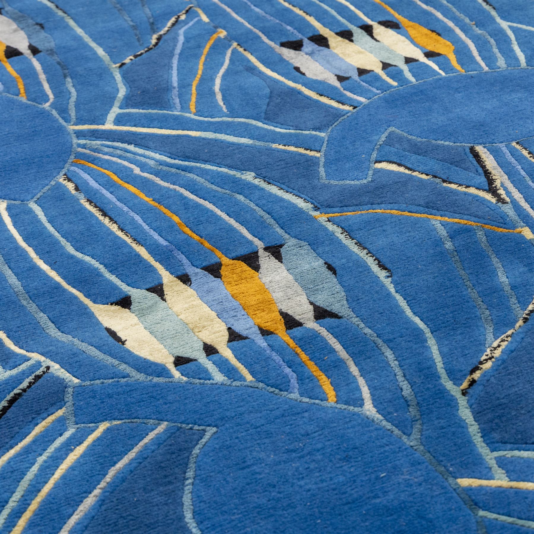 Rugs by Design - ‘Sweet Thames’ Nepalese thick pile wool rug, with abstract stylised floral design in layered blue tones, detailed with linear accents in cream, pale blue, black and ochre tones