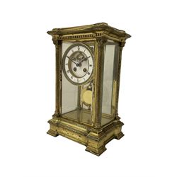 Late 19th century French brass four glass mantle clock by Samuel Marti of Paris, c1880 case on a recessed stepped plinth with four twisted columns and Corinthian capitals to the four corners, with a two- part enamel dial, Roman numerals and minute markers, non matching steel hands and visible Brocot escapement with cornelian pallets, 8-day rack striking movement stamped “medaille de bronze” with chamfered pendulum and key.