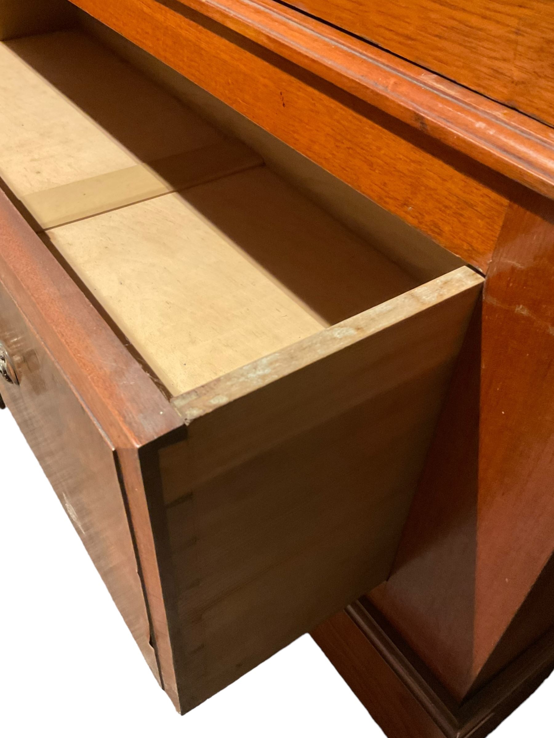 Late Victorian walnut wardrobe, carved arched pediment, fitted with single bevelled mirror door, flanked by carved and figured panels, enclosing hanging rail and hooks, single drawer fitted to base