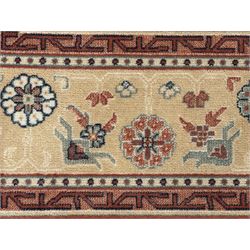 Late 20th century Royal Keshan 'Agra' hand-knotted wool rug, terracotta ground with central floral medallion and scrolling vines, enclosed by a cream border with repeating floral motifs