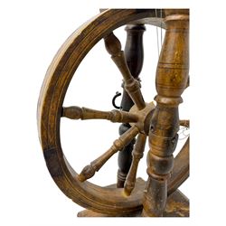 Late 19th century turned beech spinning wheel, upright form with single treadle, triangular base, and a flyer and bobbin assembly surmounted by a turned finial.