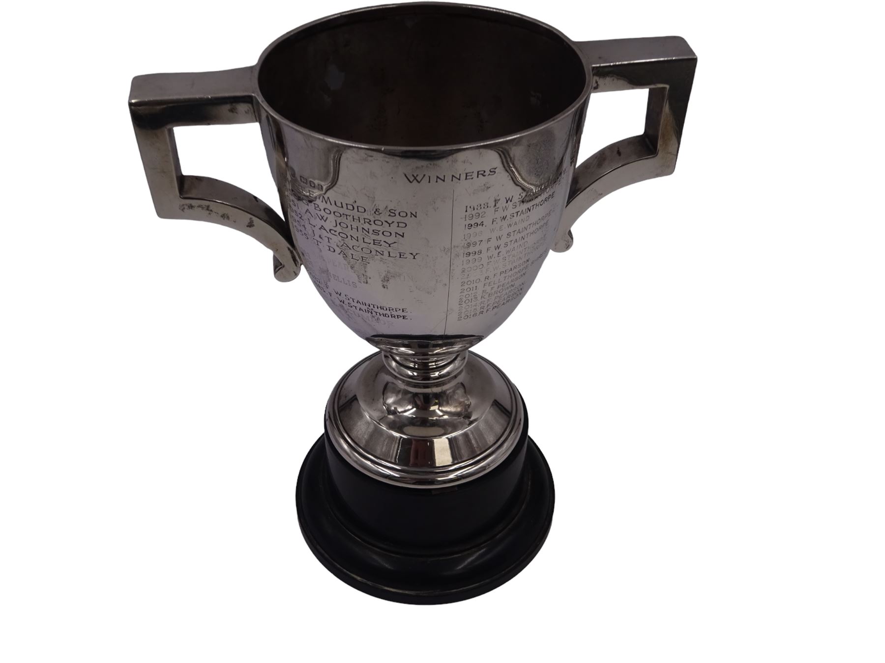 1920s silver trophy cup, with angular twin handles, upon knopped stem with circular spreading foot, the body with presentation engraving 'Burniston & District Show, presented by S Fox Linton TD MD, for the Best Agricultural Mare or Gelding, 10 miles radius, 1928' and engraved with winners verso, hallmarked Charles Boyton & Son 1921, upon black plastic base, including base 25cm
