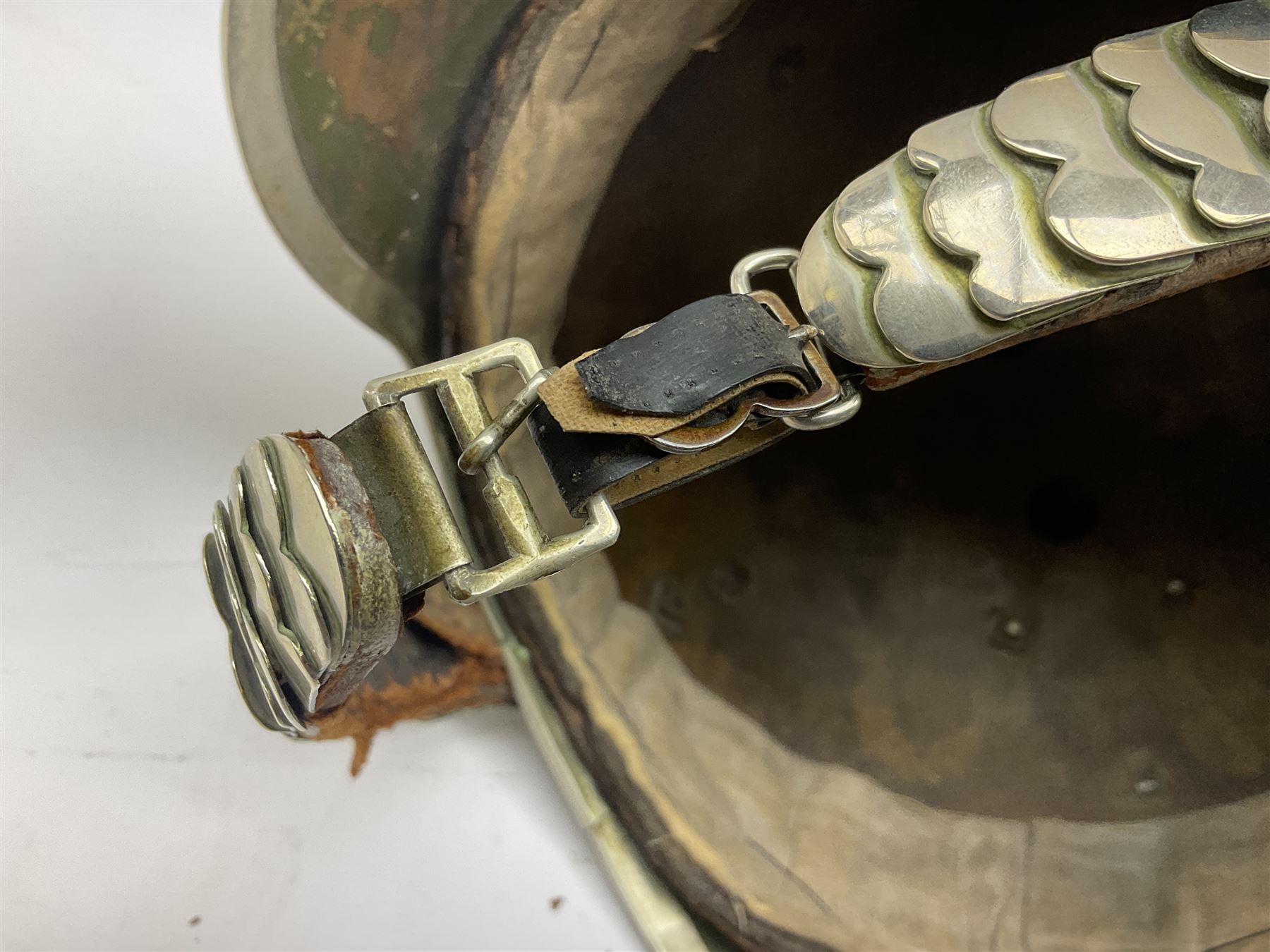 Early 20th century French mounted gendarme's helmet, brass with nickel-silver mountings, broad band embossed with fused grenade, high comb with the face of the gorgon Medusa at the peak and with a black horse hair crest, plume socket at the left, leather-backed nickel-silver chin scales with lion mask mounts.