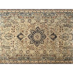 Persian ivory ground rug, central floral pole medallion surrounded by scrolling foliate branches and swirls, with matching pale blue spandrels, the guarded blue border decorated with repeating palmettes 
