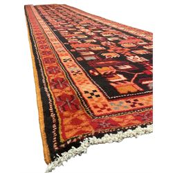 North West Persian Heriz runner, dark indigo ground field decorated with Herati motifs, peach and red borders with geometric design 