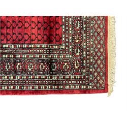 Tekke Ensi crimson ground rug, the quartered field decorated with candelabra motifs, multi-guarded border with repeating geometric hexagonal lozenges in blue and ivory