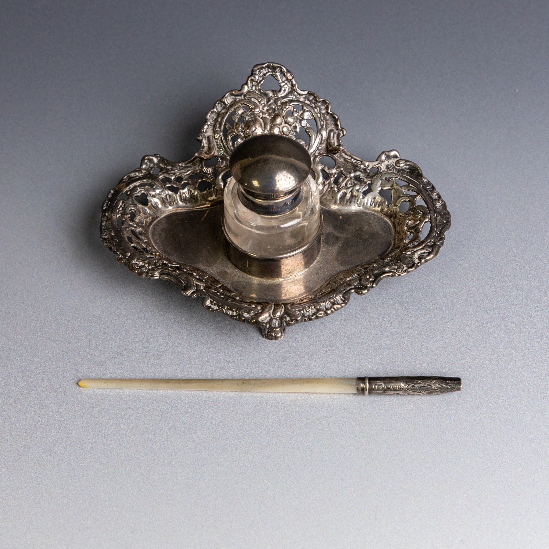 Victorian silver inkwell stand, with silver topped inkwell, hallmarked Lawrence Emanuel, Birmingham 1893, together with a mother of pearl dip pen with silver collar and two silver topped jars, one with guilloche enamel decoration, all hallmarked