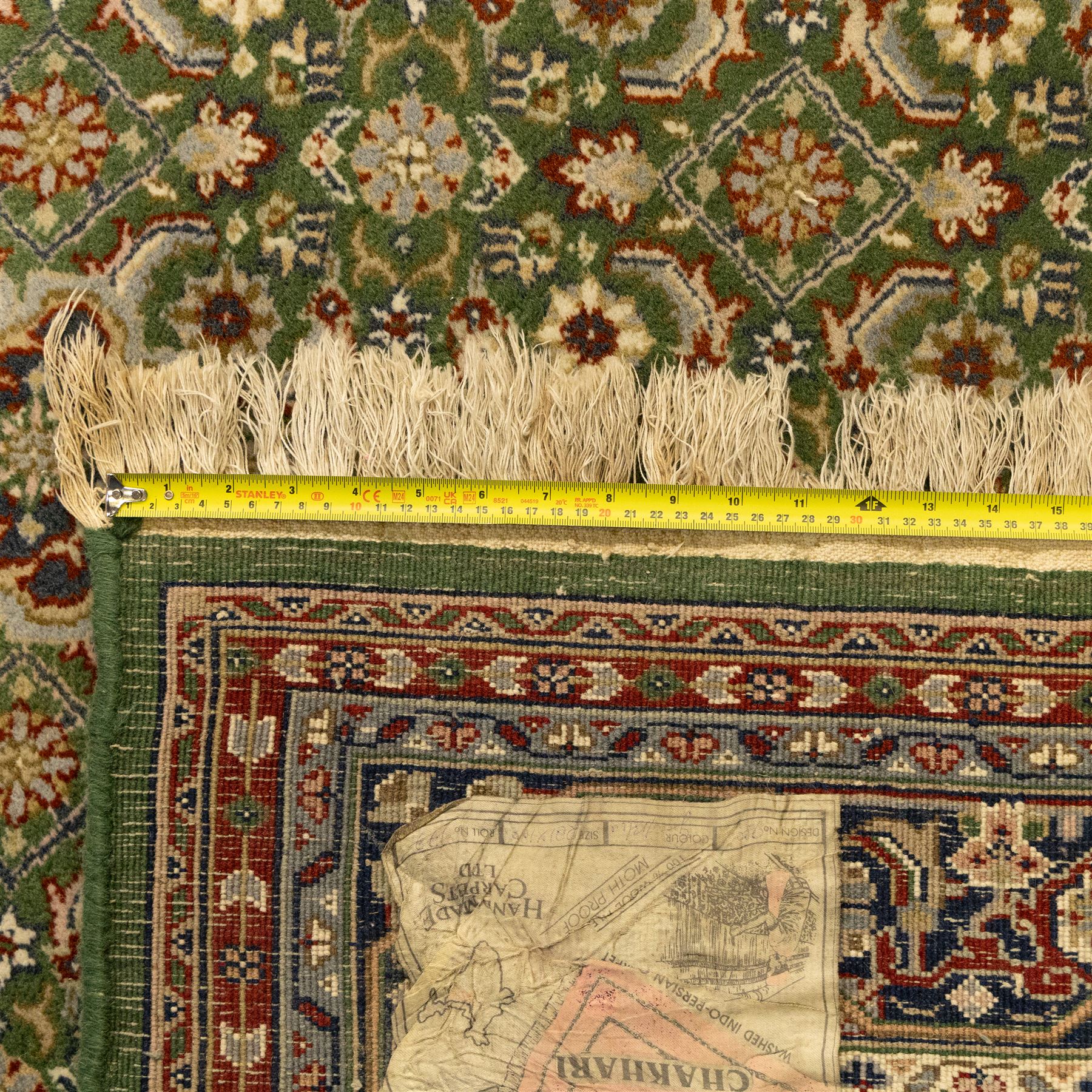 Central Persian Kashan rug, emerald green ground, with a central ivory, indigo, and brick red lobbed medallion with pendant finials, ivory spandrels, framed by multiple floral borders