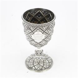Victorian silver trophy cup or goblet, the cup with personally engraved quatrefoil panel and beaded rim, upon a knopped flower head detailed stem and spreading circular foot, embossed throughout with a flower head diamond trellis pattern, hallmarked Robert Hennell III, London 1860, H18cm