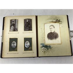 Victorian leather bound photo album, the interior leaves containing apertures of various sizes and shapes of portraits surrounded by printed floral designs, H28cm