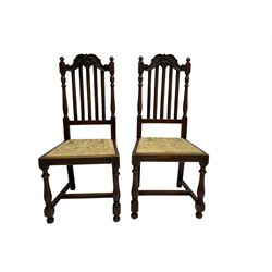 Set five early 20th century oak dining chairs, the shaped cresting rail carved with scrolls, upholstered drop in seats, on turned supports joined by H-stretchers