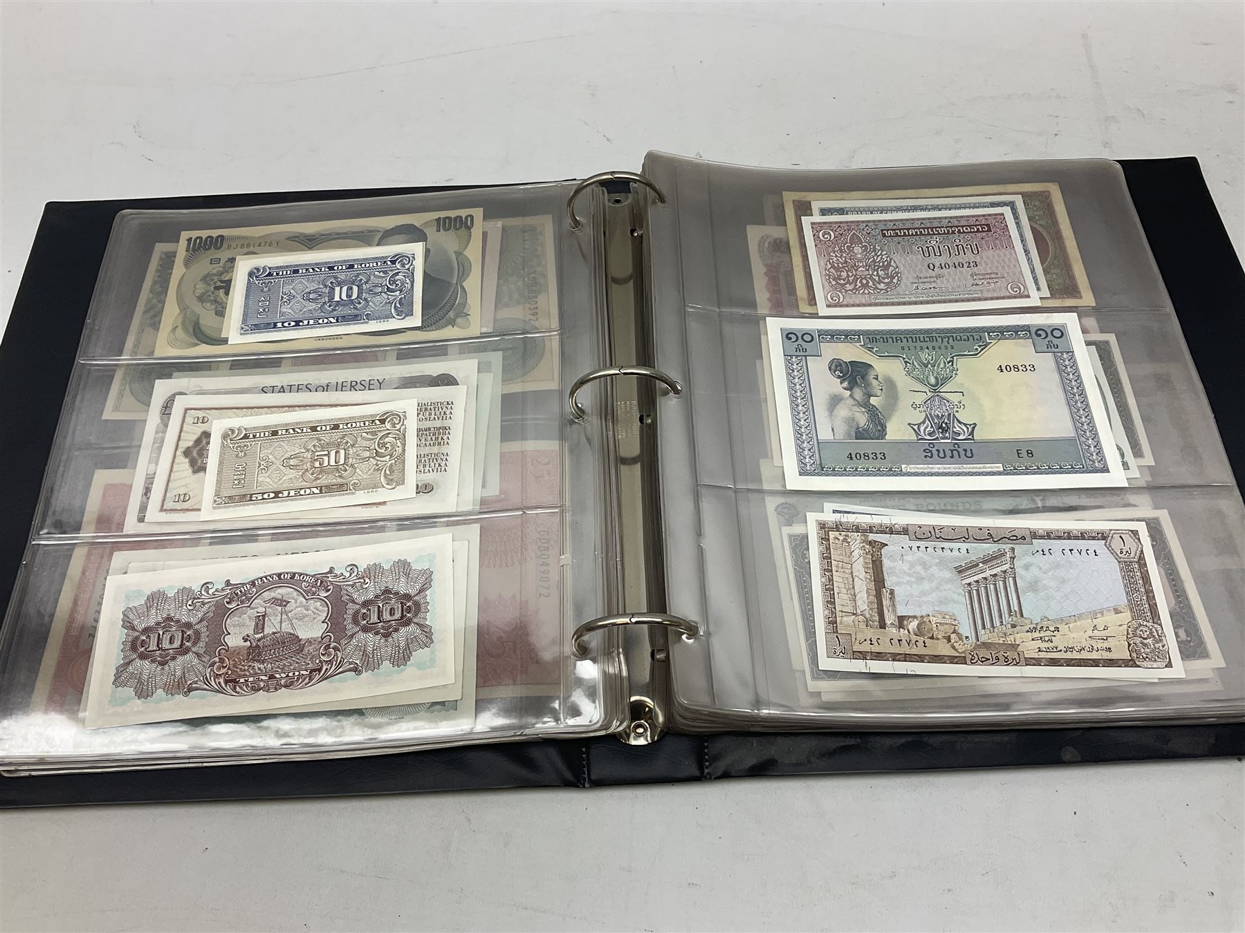 World banknotes, including Queen Elizabeth II The States of Jersey one pound 'DB202703', five pounds 'BB527762' and ten pounds 'AB651481', reserve bank of New Zealand two dollars '1L3 741894', King George V Straits Settlements one dollar 1st January 1935 'F/83 28924', various Bank of England notes etc, housed in two ring binder albums