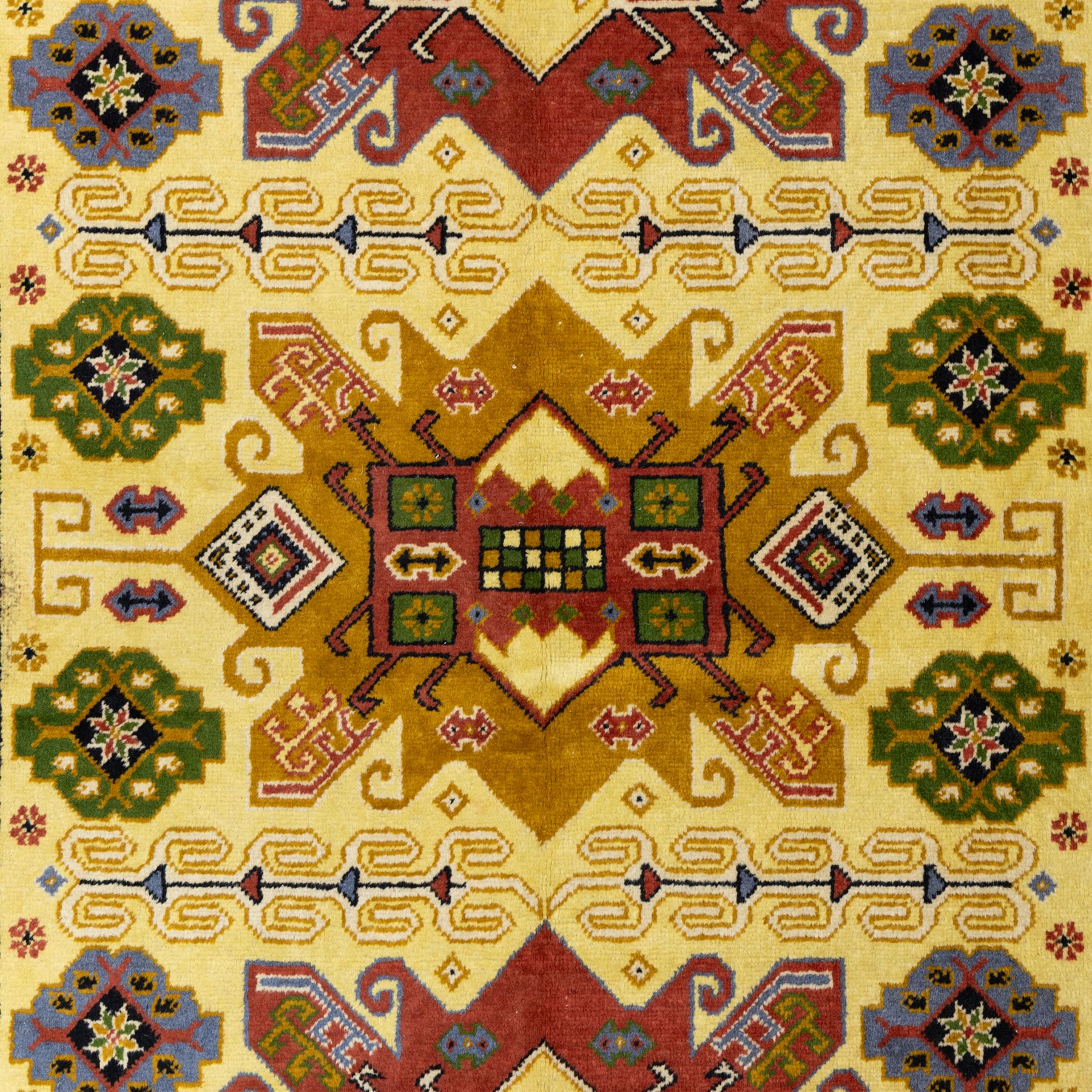 Caucasian Kazak design wool rug, cream field with three large geometric medallions and stylised hooked motifs, enclosed by polychrome reciprocal border and green floral guard stripes