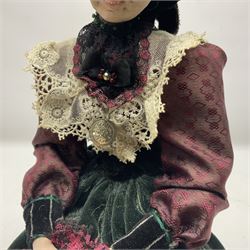 Anna Meszaros Hungary - hand made needlework finely detailed figurine of a pensive old lady seated on a stool wearing a lace trimmed long black and maroon dress and hat, clutching a lace bag H32cm Auctioneer's Note: Anna Meszaros came to England from her native Hungary in 1959 to marry an English businessman she met while demonstrating her art at the 1958 Brussels Exhibition. Shortly before she left for England she was awarded the title of Folk Artist Master by the Hungarian Government. Anna was a gifted painter of mainly portraits and sculptress before starting to make her figurines which are completely hand made and unique, each with a character and expression of its own. The hands, feet and face are sculptured by layering the material and pulling the features into place with needle and thread. She died in Hull in 1998.