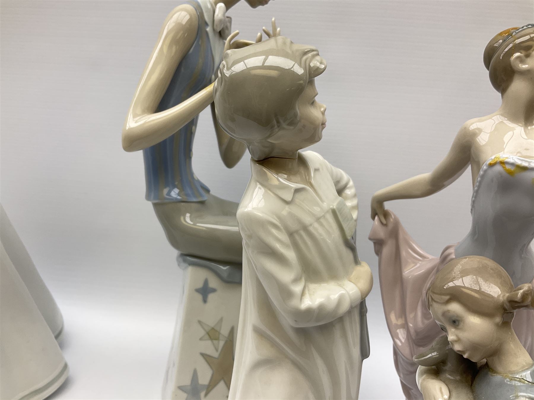 Collection of seven Lladro figures, including Seated ballerina with swan 6204, Childhood Dream 8129, Dancer 5050, reclining clown with ball alongside a selection of other figures. 