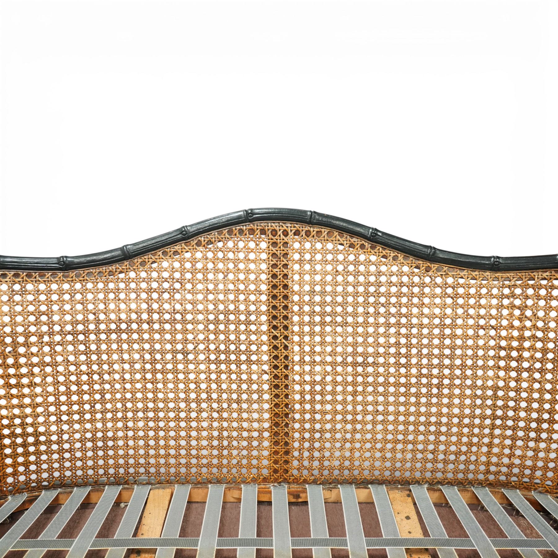 Early 20th century French bergère settee, the shaped caned back flanked by caned sides and scrolling arms, moulded beech frame with dark painted finish, serpentine seat rail with webbing, on cabriole legs with pad feet