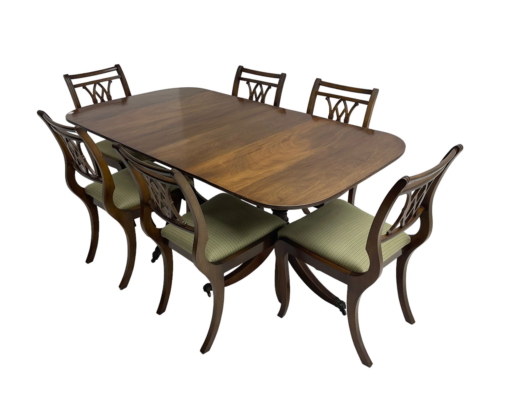 Regency design mahogany twin pedestal dining table, rectangular top with reeded edge, acanthus carved turned column terminating in reeded tripod base with hairy paw feet and castors (W172cm D92cm H75cm) and set eight (6+2) Regency design mahogany dining chairs, pierced back with scroll design, seat upholstered in patterned laurel green fabric, raised on reeded sabre supports (W48cm H88cm)