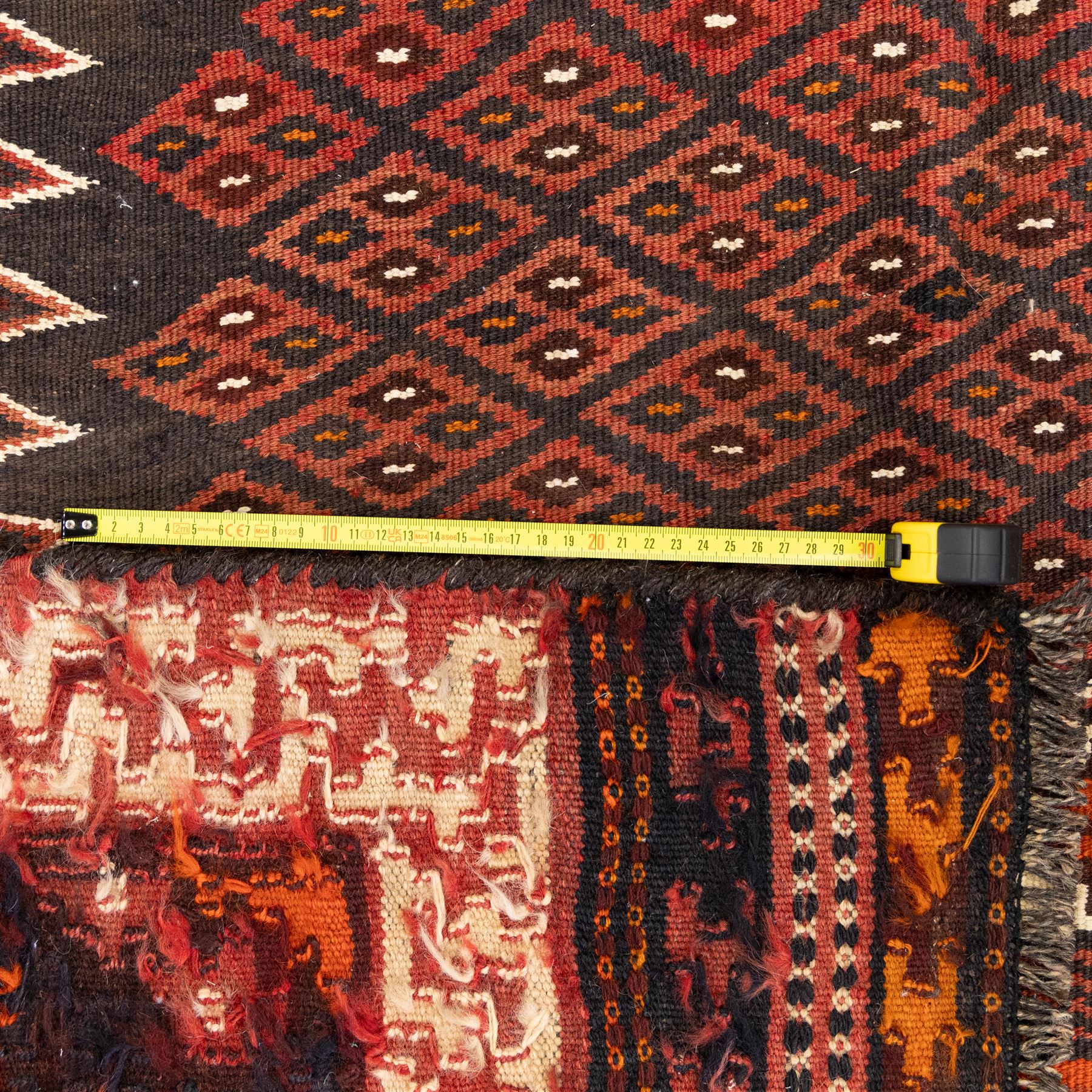 North west Persian Yamut Kilim, madder field with all-over lozenge lattice and serrated edges, with stepped end-panels and bold geometric borders in red, ivory and black