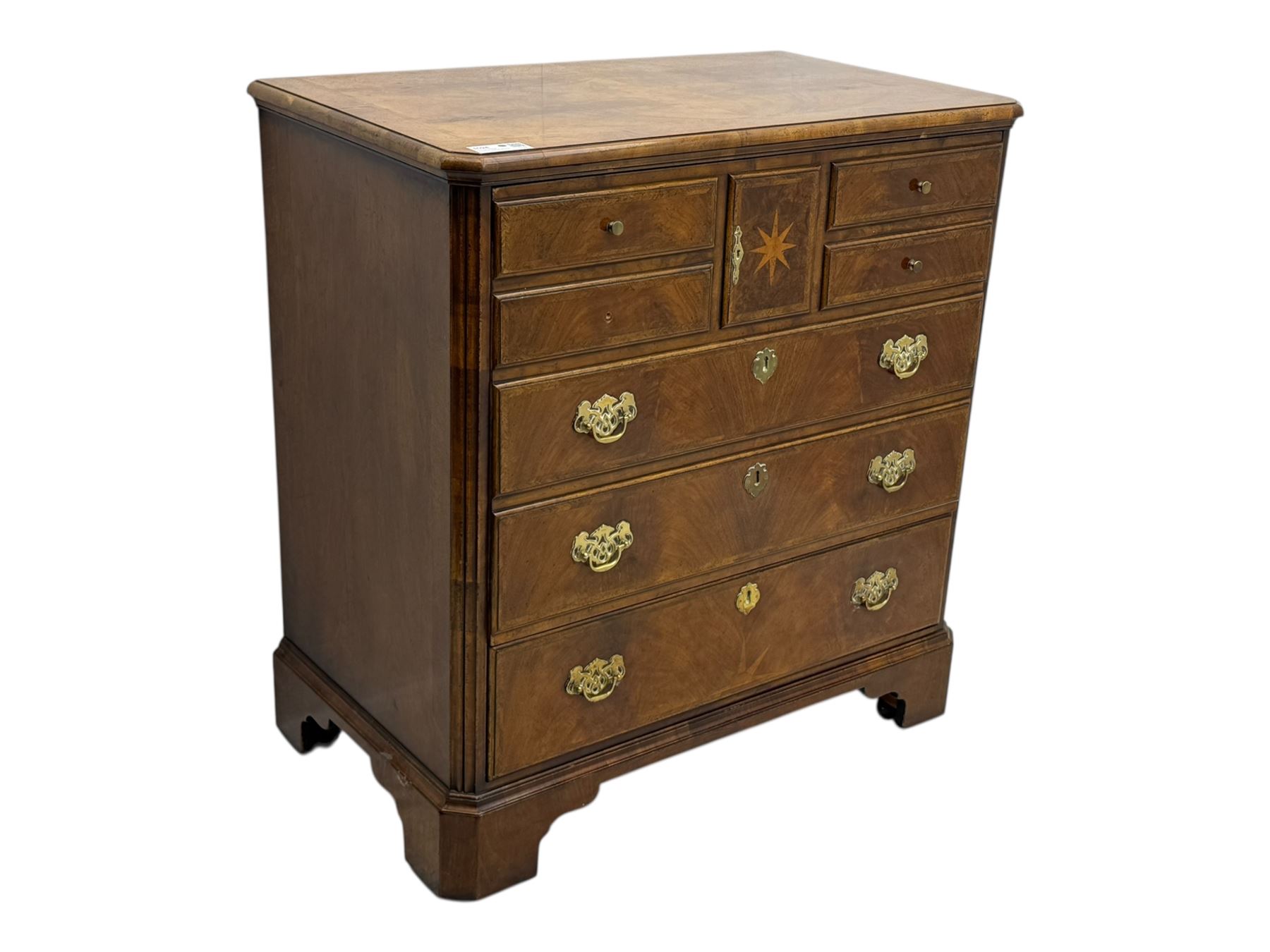 Late 20th century walnut veneered television chest in Georgian style, rectangular top over simulated drawer front with central marquetry star inlay, opening to a shelved TV compartment, lower section fitted with one long drawer, brass handles and ogee bracket feet