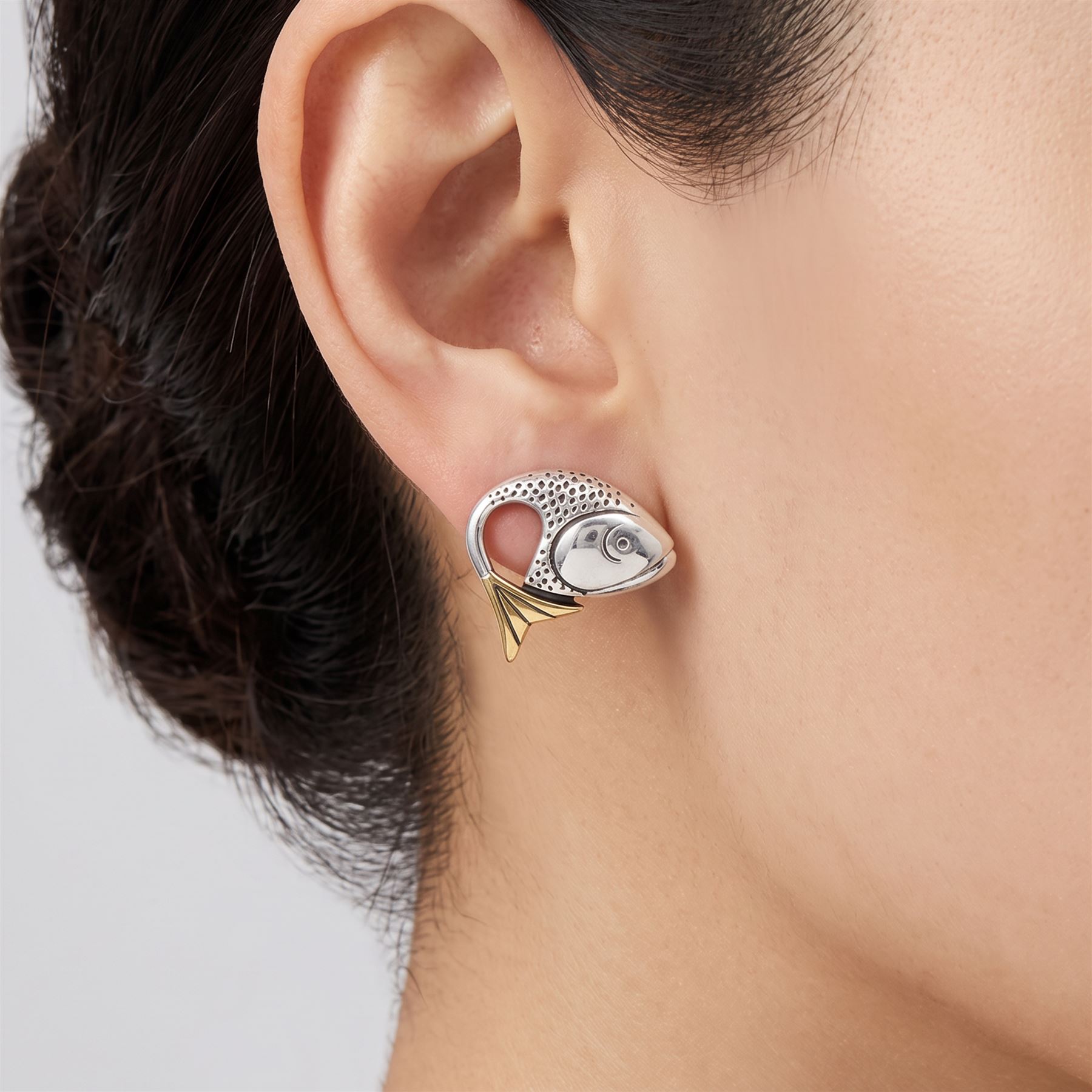 Brett Payne pair of silver and 9ct gold fish earrings, each stud set with a single silver fish head and 9ct gold tail, Sheffield 1998