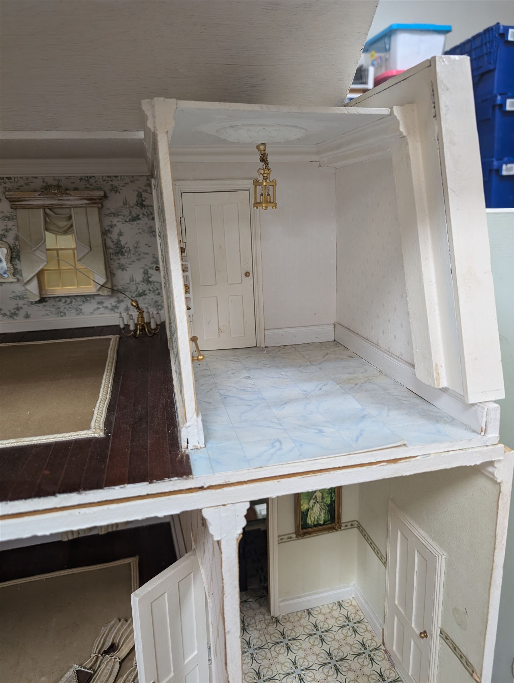 Two modern three storey dolls houses, each painted green with decorated interiors, both upon a single white wooden base, together with a large collection of dolls house furniture, accessories and figures 