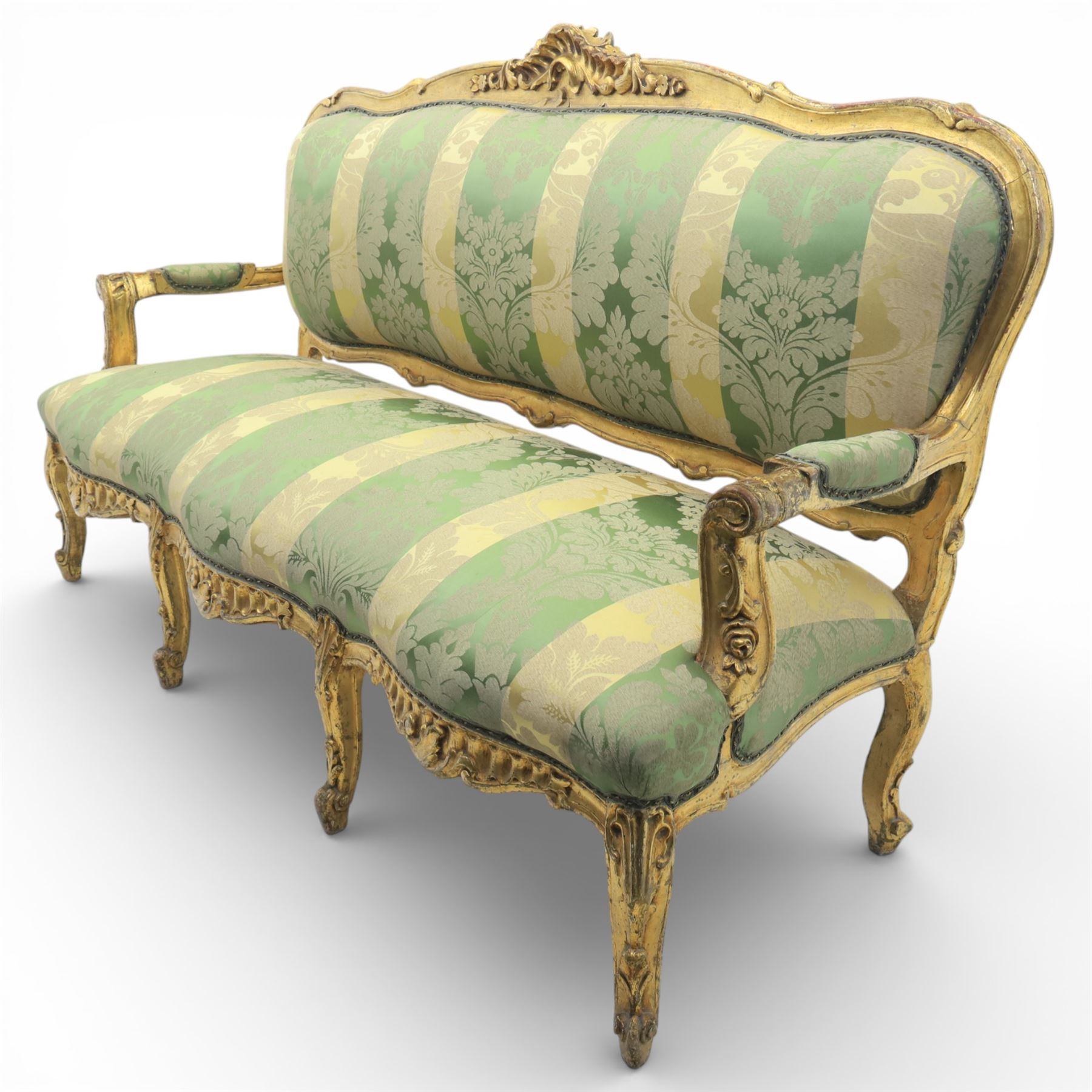 20th century French Louis XV style giltwood salon sofa, with shaped and moulded serpentine cresting rail carved with central scroll motif, padded back and seat upholstered in green and gold striped damask fabric, scroll carved open arms with padded rests, shaped apron carved with rocaille and foliate motifs, raised upon cabriole legs
