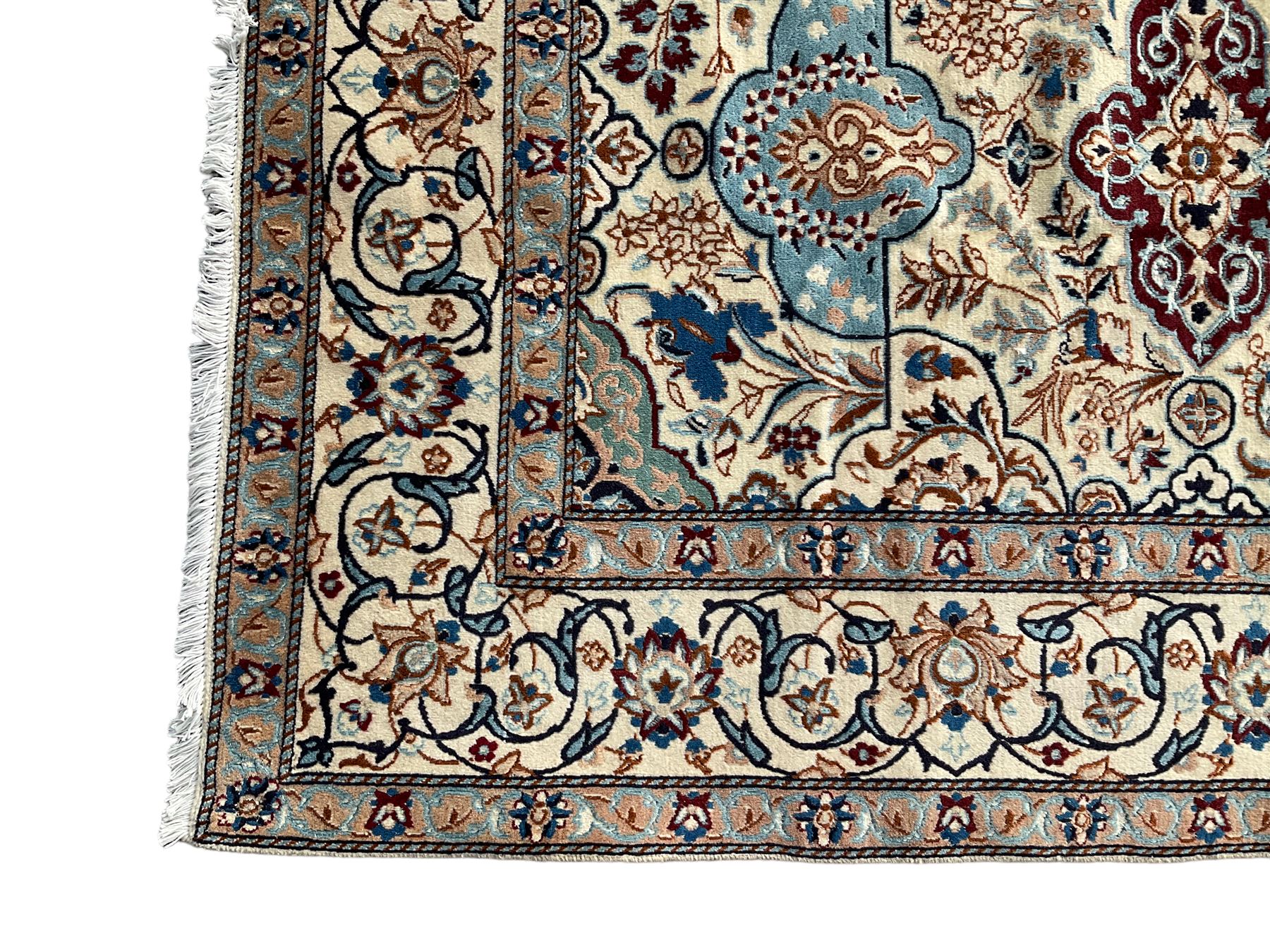 Persian Nain ivory ground rug, wool with silk inlay, the field decorated with stylised gul motifs with palmettes surrounded by interlacing foliate patterns, the guarder border decorated with repeating flower heads and scrolling vines