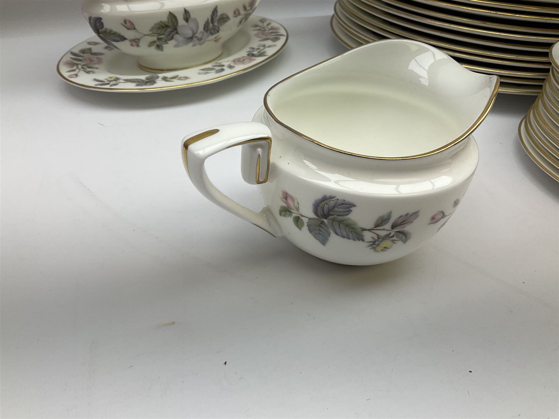 Royal Worcester June Garland pattern tea and dinner wares, comprising thirteen dinner plates, twelve dessert plates, twelve side plates, six twin handled soup bowls and six saucers, six small bowls, sauce boat and stand, thirteen teacups and fifteen saucers, open sucrier, and milk jug