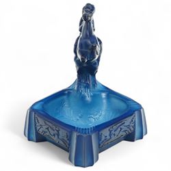 Early 20th century art deco style lapis glass ashtray, in the manner of Frantisek Pazourek, depicting a nude maiden astride a reared horse, possibly Lady Godiva, the bowl with raised foliate decoration, each side panel depicting leaping deer in light relief, flat base with fluted corner decoration, W7cm