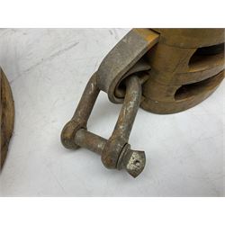 Three ship pulleys comprising wooden block double with swivel eye marked 'wooden block 240mm double rope: 22mm',  wooden block double with upset shackle and wooden block with stiff swivel hook, largest example L50cm