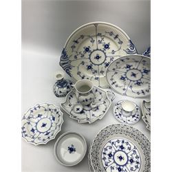 A collection of assorted Royal Copenhagen blue fluted lace tablewares comprising a pierced fruit basket, sugar sifter, pair of candlesticks, reticulated plate, two leaf shaped serving dishes, salt cellar, two egg cups, pepper pot, two large twin handled plates, together with other Royal Copenhagen porcelain (19)