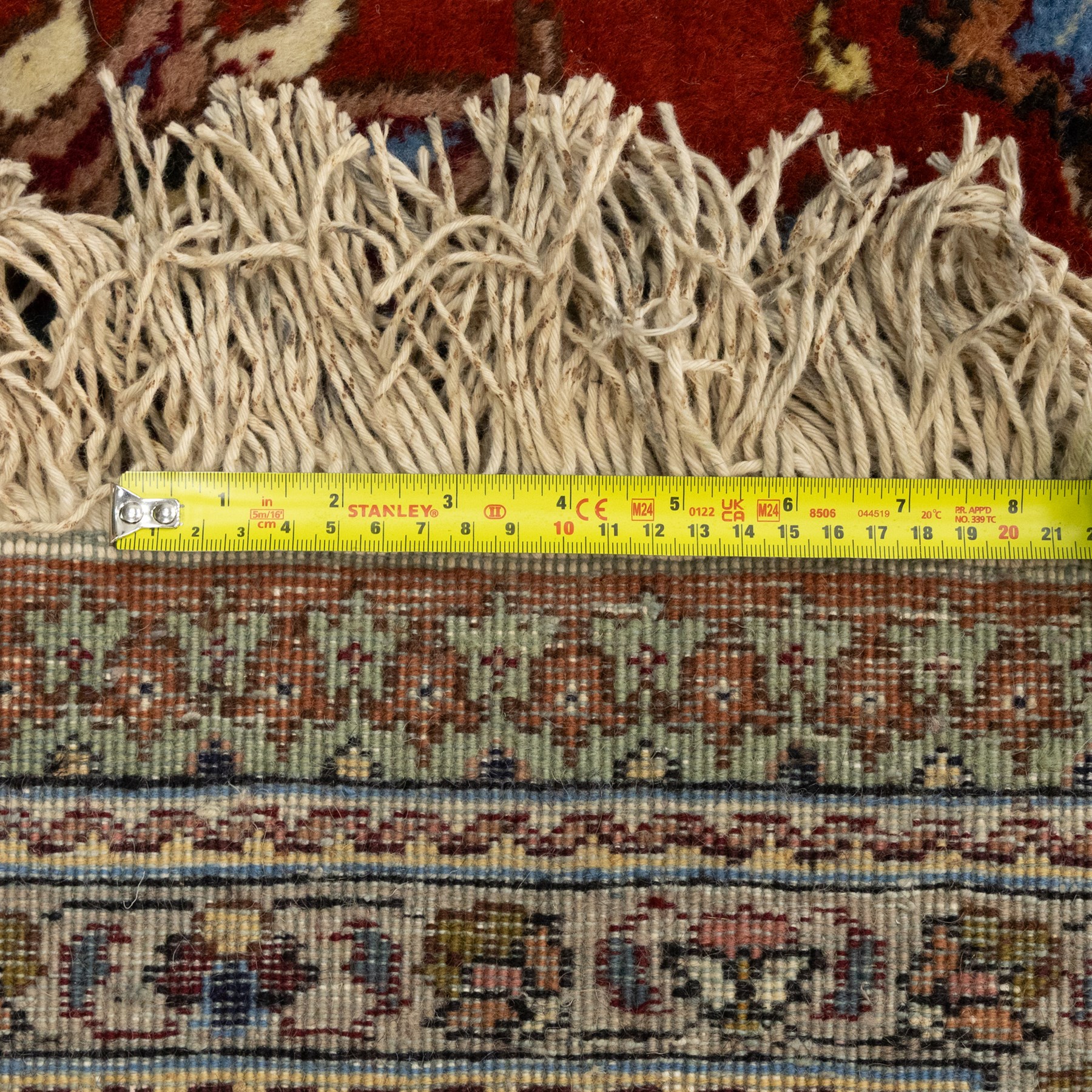 Persian Tabriz hand-knotted carpet, crimson field densely decorated with scrolling floral and foliate motifs, enclosed by a broad cream principal border with repeating floral medallions and multiple guard stripes