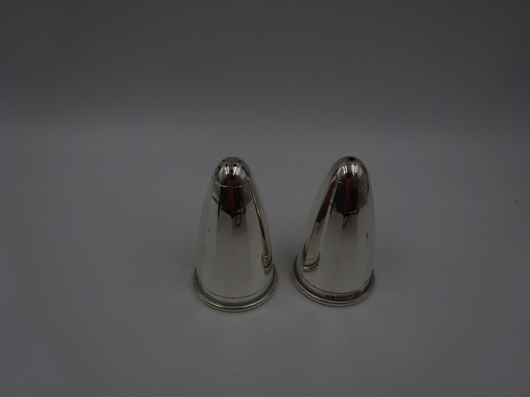 Pair of modern silver salt and pepper shakers, of tapering faceted form, hallmarked Laurence R Watson & Co, Birmingham 2009, H7cm, boxed 