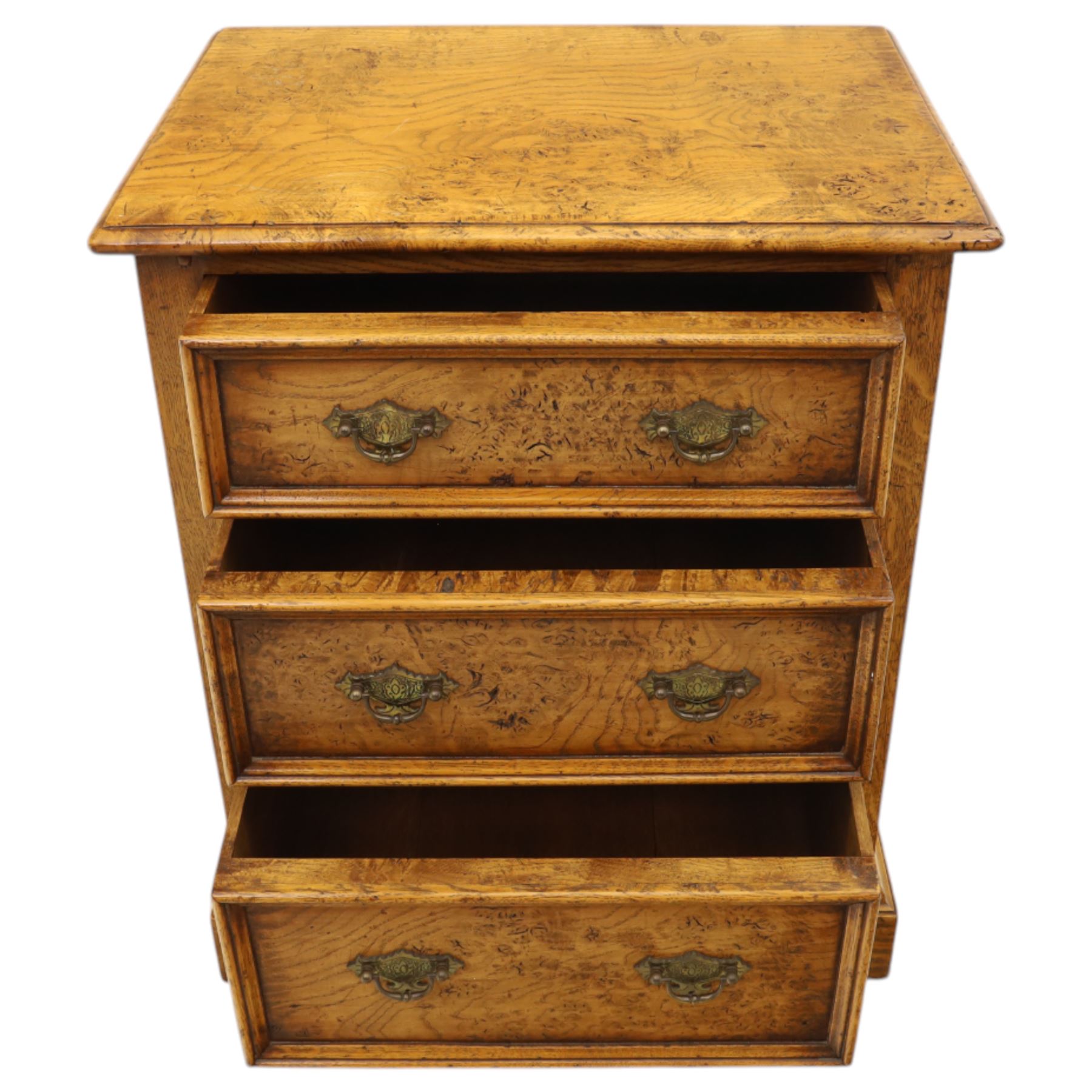 Small 20th century burr oak chest, the figured top over three graduated drawers with moulded fronts and pierced brass handles, on shaped feet