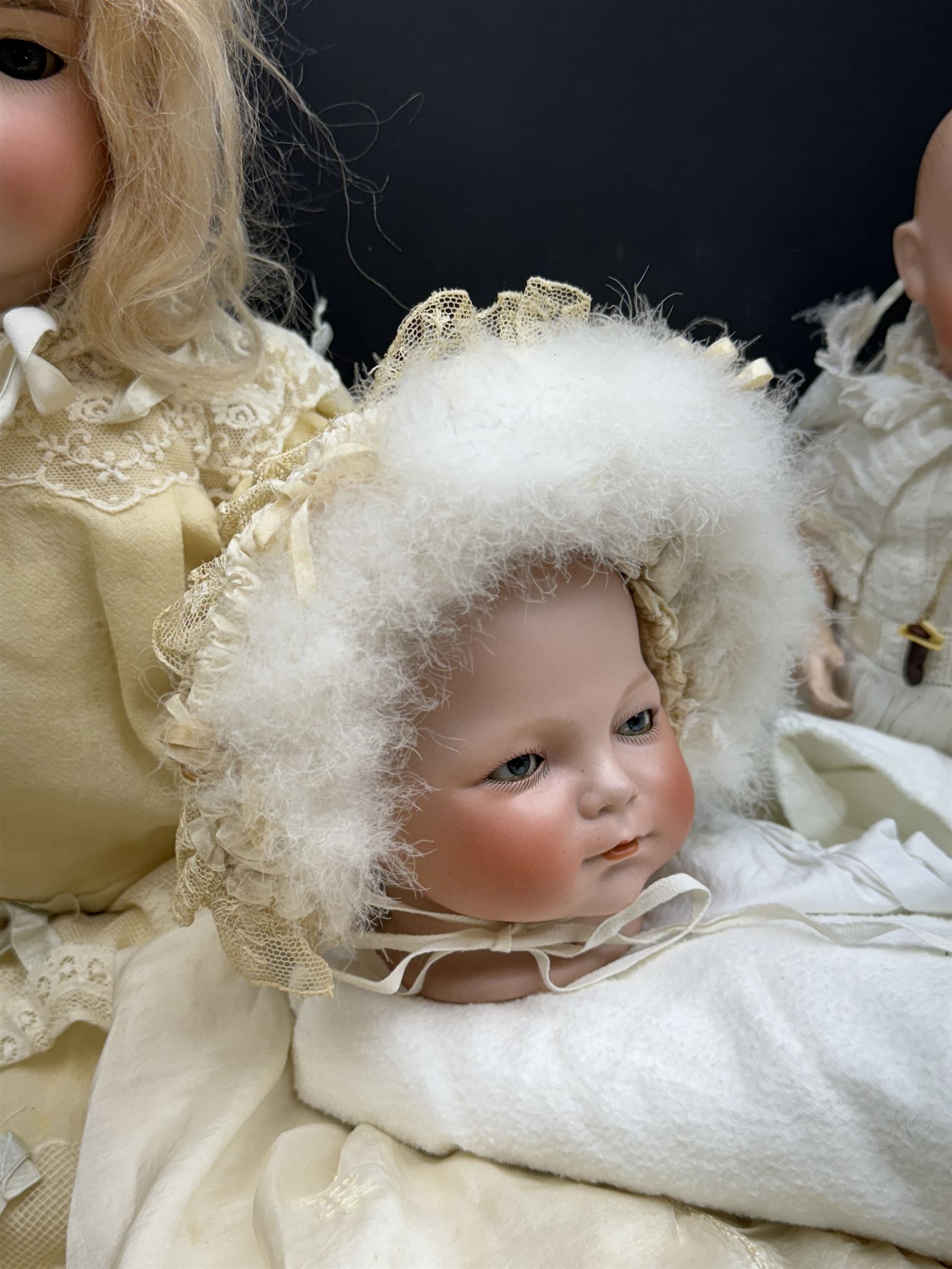 Two German bisque head dolls, to include a Franz Schmidt example with blue glass eyes and an Armand Marseille 590 example with applied hair, together with a Schoenau & Hoffmeister bisque doll's head, pair of doll's hands and a collection of clothing