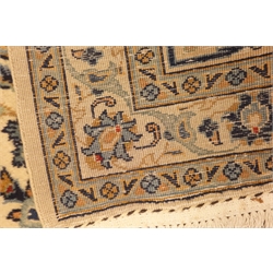  Persian Kashan carpet, ivory ground with blue interlacing overall design, repeating scroll border, decorated with stylised flower heads, 405cm x 311cm  