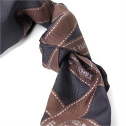 Hermès - two ‘Bolduc’ silk Twilly scarves, in orange/black and navy/brown colourways, together with three palladium-tone Médor pyramid Twilly scarf rings, with original dust bag and cylindrical box