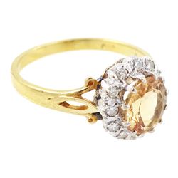 18ct gold imperial topaz and diamond cluster ring, oval cut topaz of approx 1.50 carat, surrounded by twelve round brilliant cut diamonds, London 1987, total diamond weight approx 0.10 carat