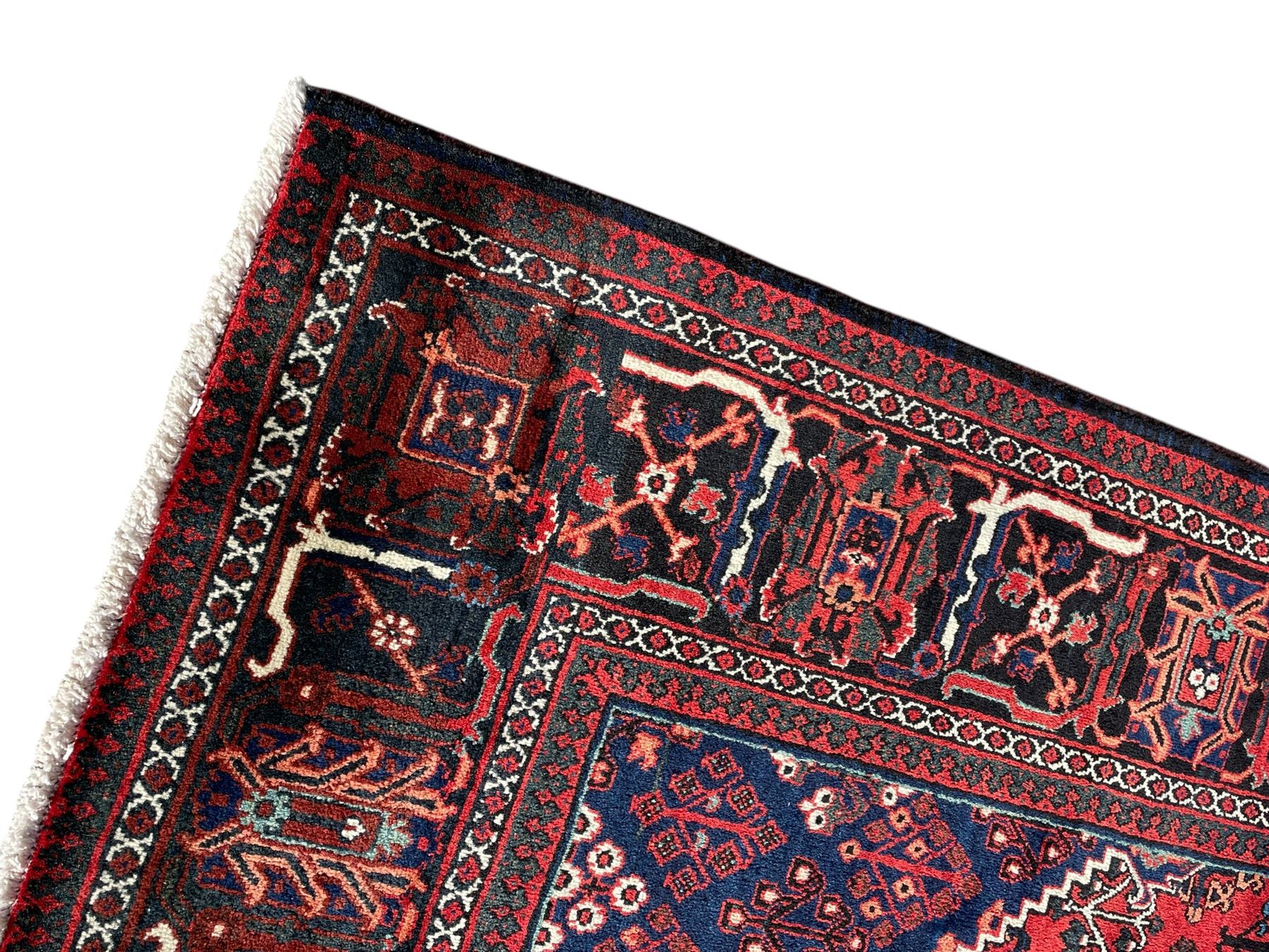 Persian Joshaghan crimson ground rug, stepped lozenge medallion surrounded by repeating foliate lozenge motifs, the border decorated with stylised plant motifs, within geometric guard stripes