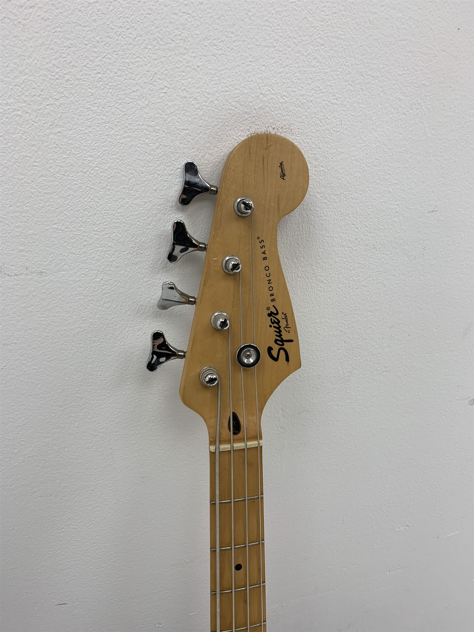  Fender Squier Bronco Affinity Series electric bass guitar, in black and white, serial no. IC021107489, L108cm, in associated Squier soft carrying case. From the collection of the late John Burgess of Beverley who played in the bands Penjants, Wine, Strollers, Revox, Sound Foundation, Pickle Belly Alley, Ragamuffins and Jerryattricks.