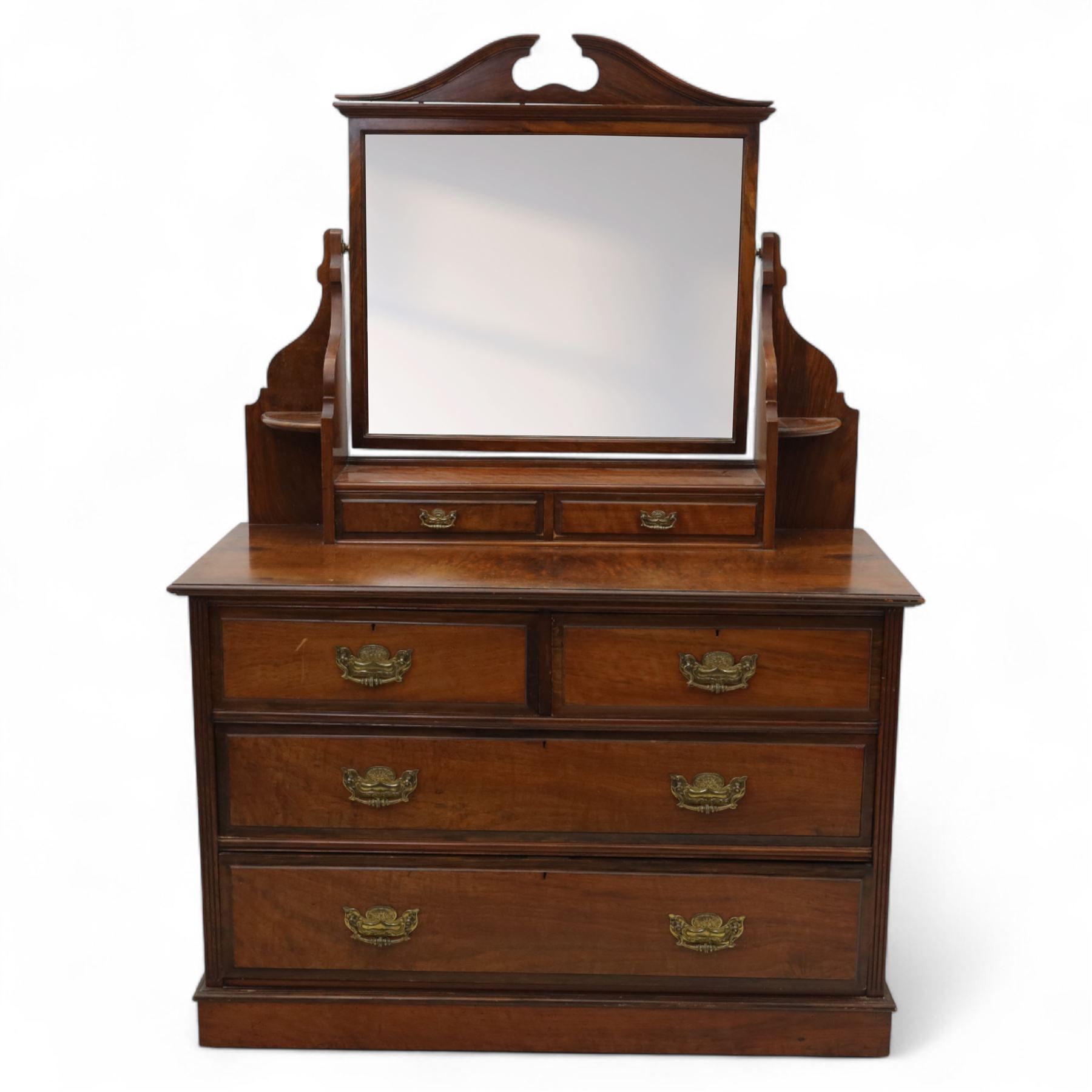 Edwardian walnut dressing chest, rectangular top surmounted by a mirror frame with shaped pediment on swing supports above two short frieze drawers over two short and three long graduated drawers fitted with brass foliate handles, raised on a plinth base