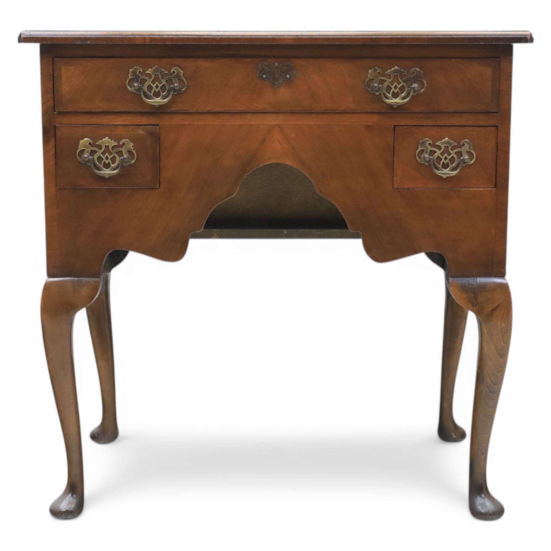 Early 20th century walnut lowboy in Queen Anne style, rectangular crossbanded top over single long drawer and two short drawers with shaped apron, fitted with brass drop handles and backplates, raised on cabriole supports terminating in pad feet
