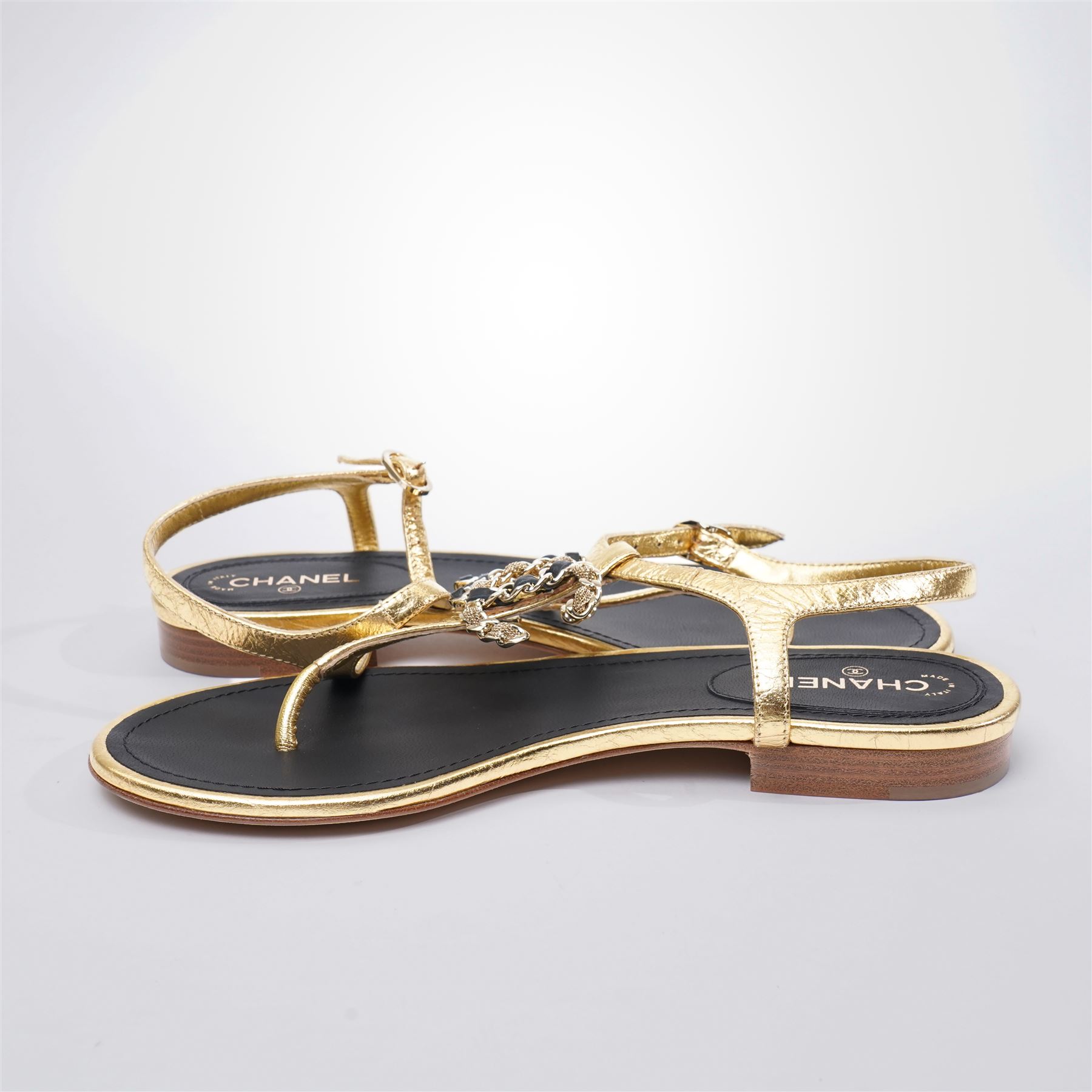 Chanel - pair of gold leather thong sandals, from the 2021 Summer Collection, the uppers centred with an interlocking gold tone CC motif in chain and leather, size 37C, unused with original dust bags