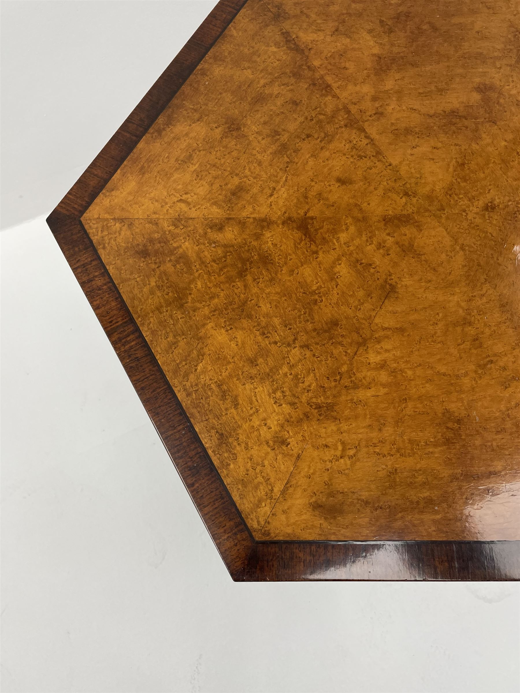 Regency style birdseye maple and rosewood tripod table, hexagonal tilt top with segmented veneer and banding, tapered hexagonal column on three splayed serpentine supports, brass cups and castors 