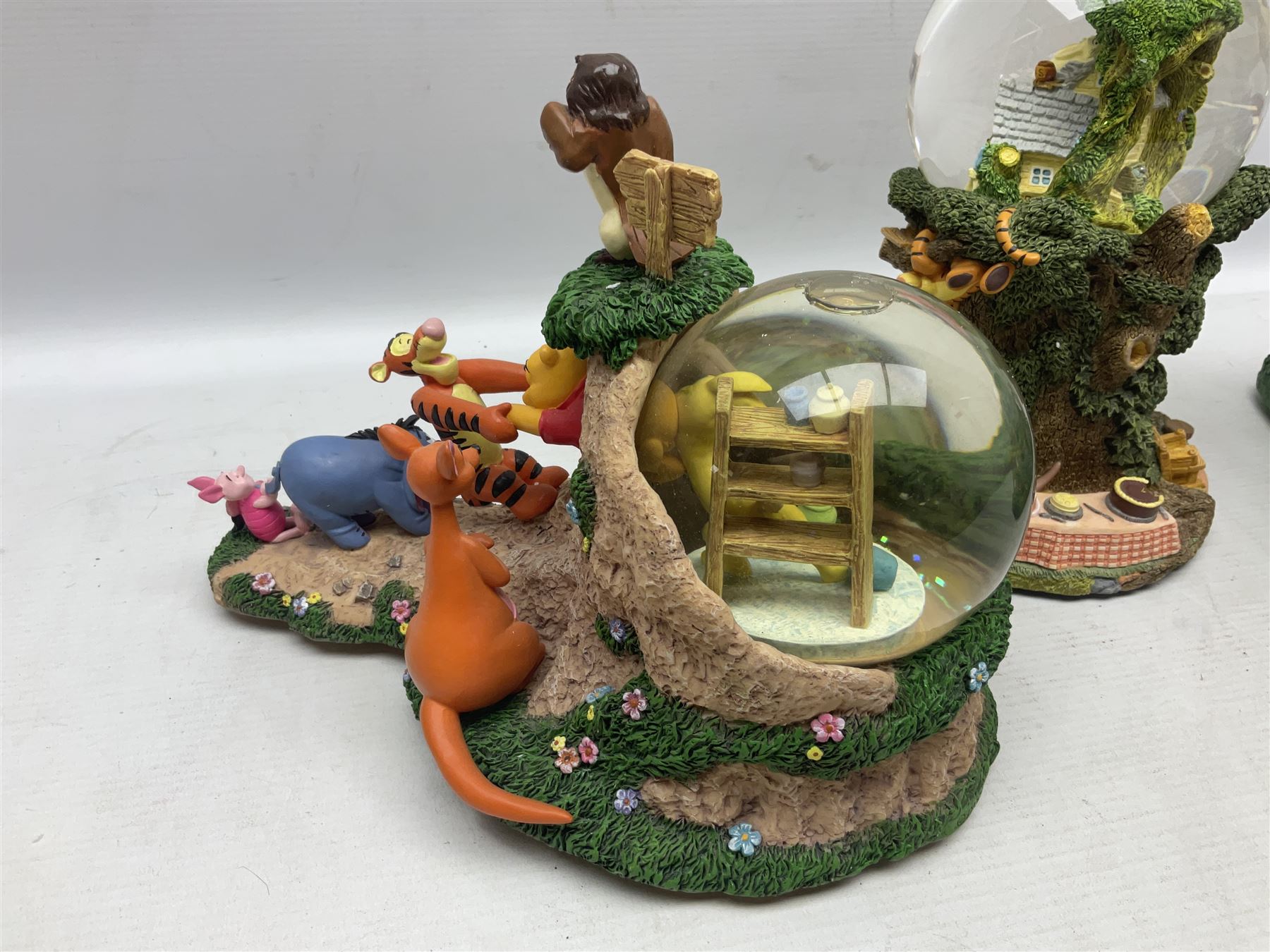 Five Disney Winnie The Pooh snow globes to include The Rain Rain Rain Came Down Down Down, Eeyore Pulling Cart, Owl's House, Rumbly in My Tumbly and Stuck In Rabbit's House, together with figure group with dome, five with boxes (6)