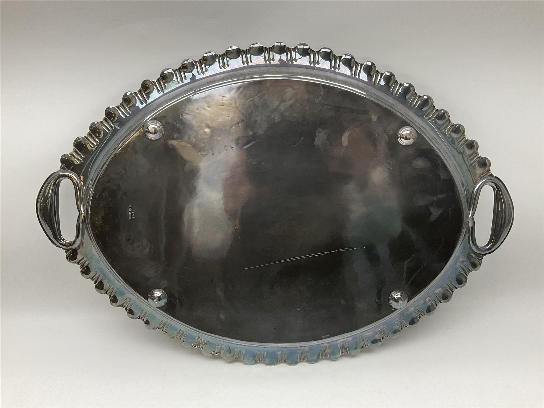Oval silver plate twin handled tray, egg and dart edge, engraved with floral springs surrounding an central inscription, L65cm